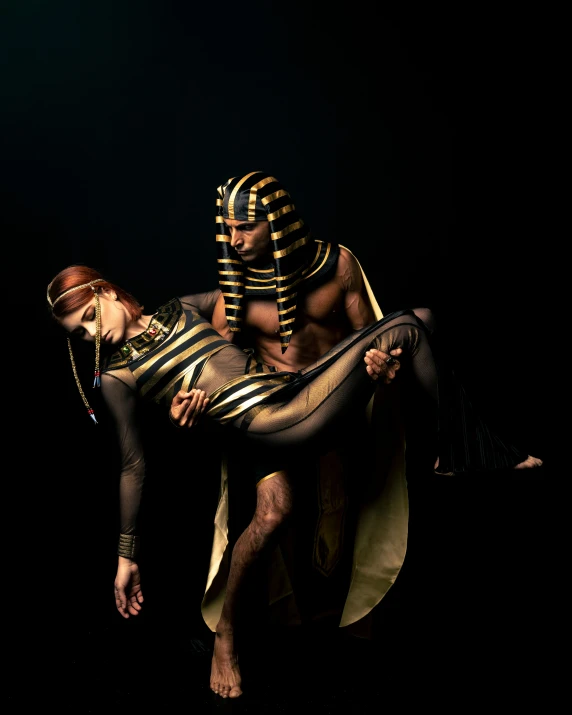 two people dressed in egyptian attire and wearing body paint