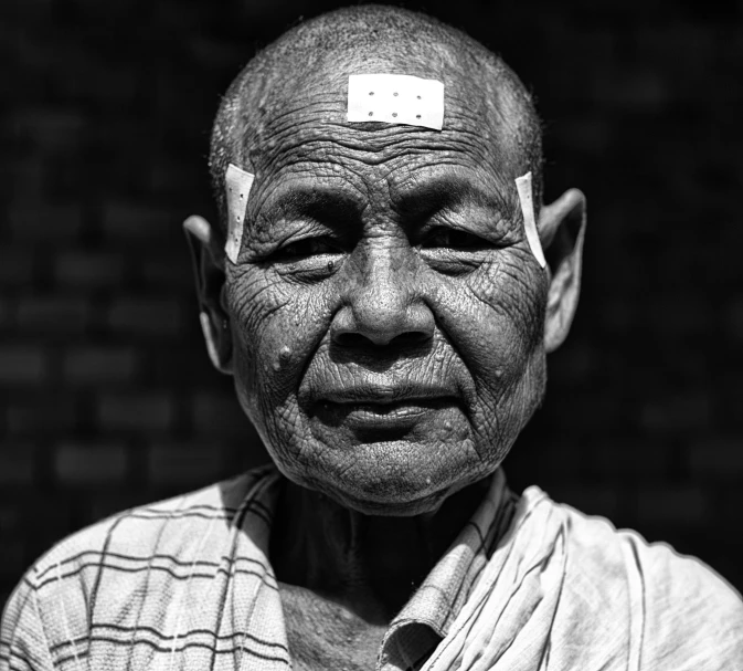 a man with sticker headband on with a brick background