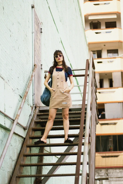 woman with blue handbag standing on stairs