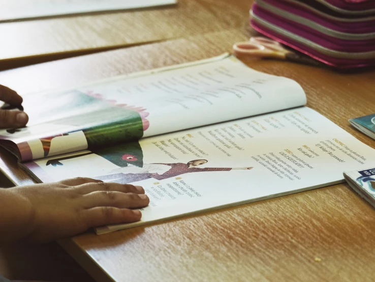 a hand reaches into a book for an article