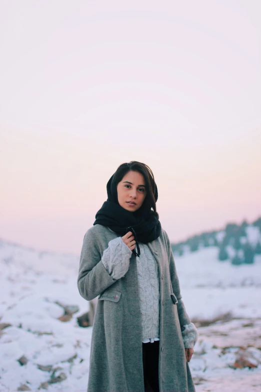 a woman wearing a gray coat and scarf