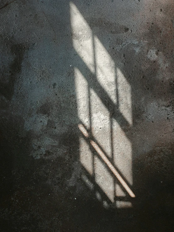 long shadow on the wall of a window in an empty building