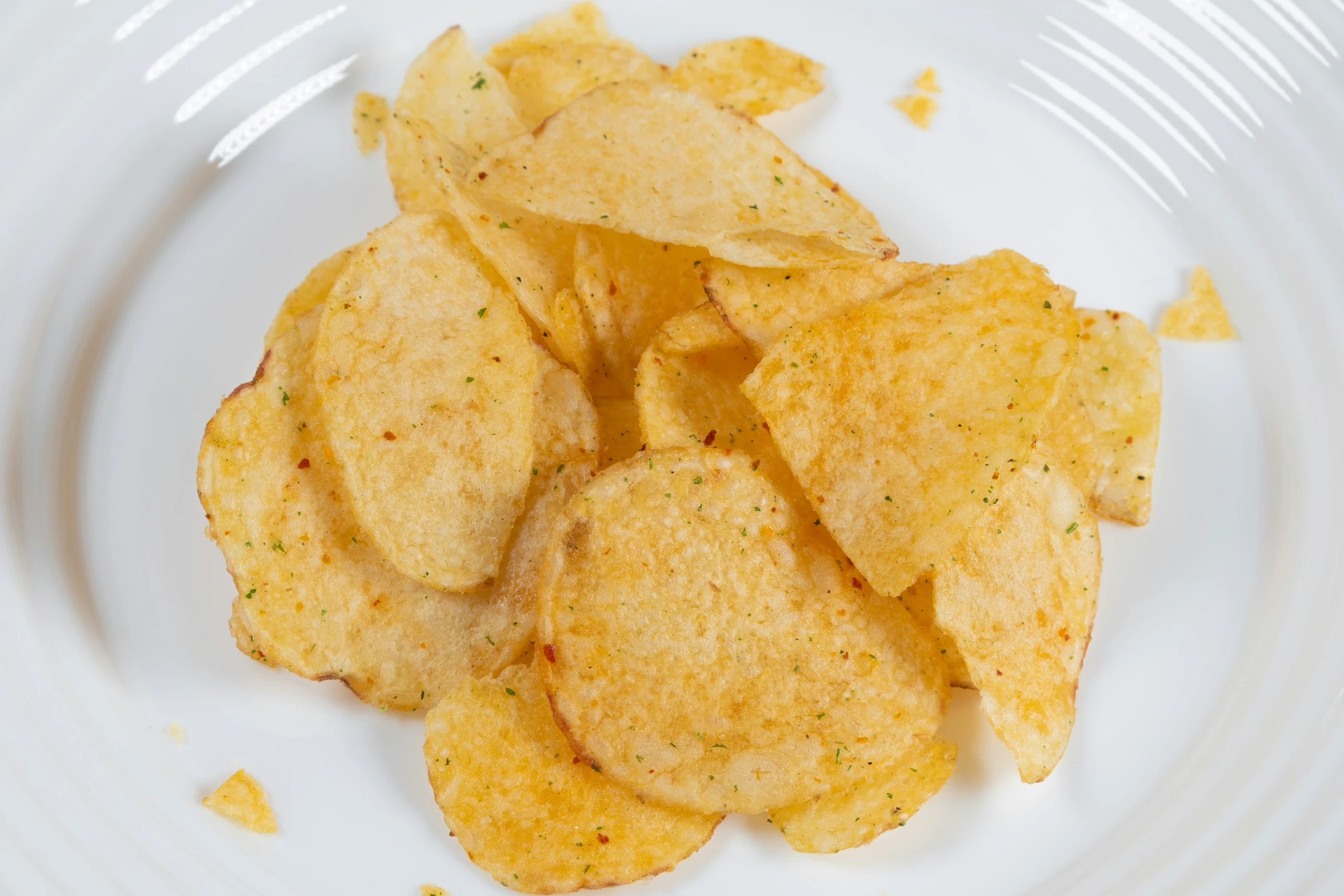 crispy potato chips with sesame on top on white plate