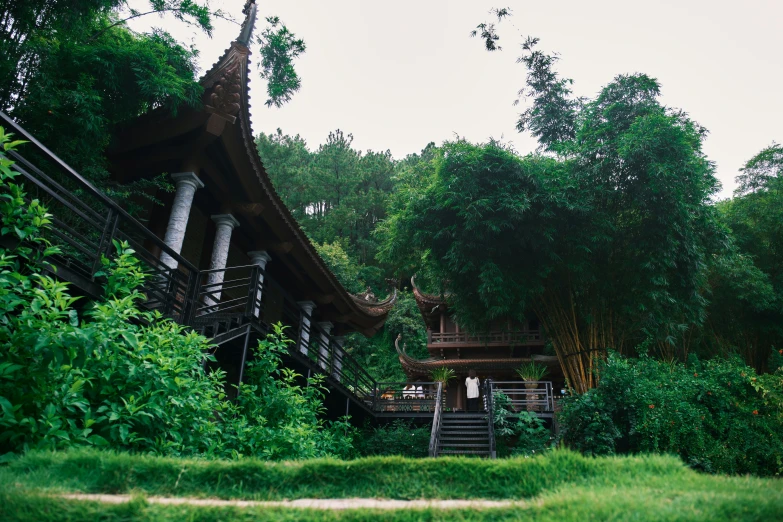 a house surrounded by trees and bushes on a cloudy day