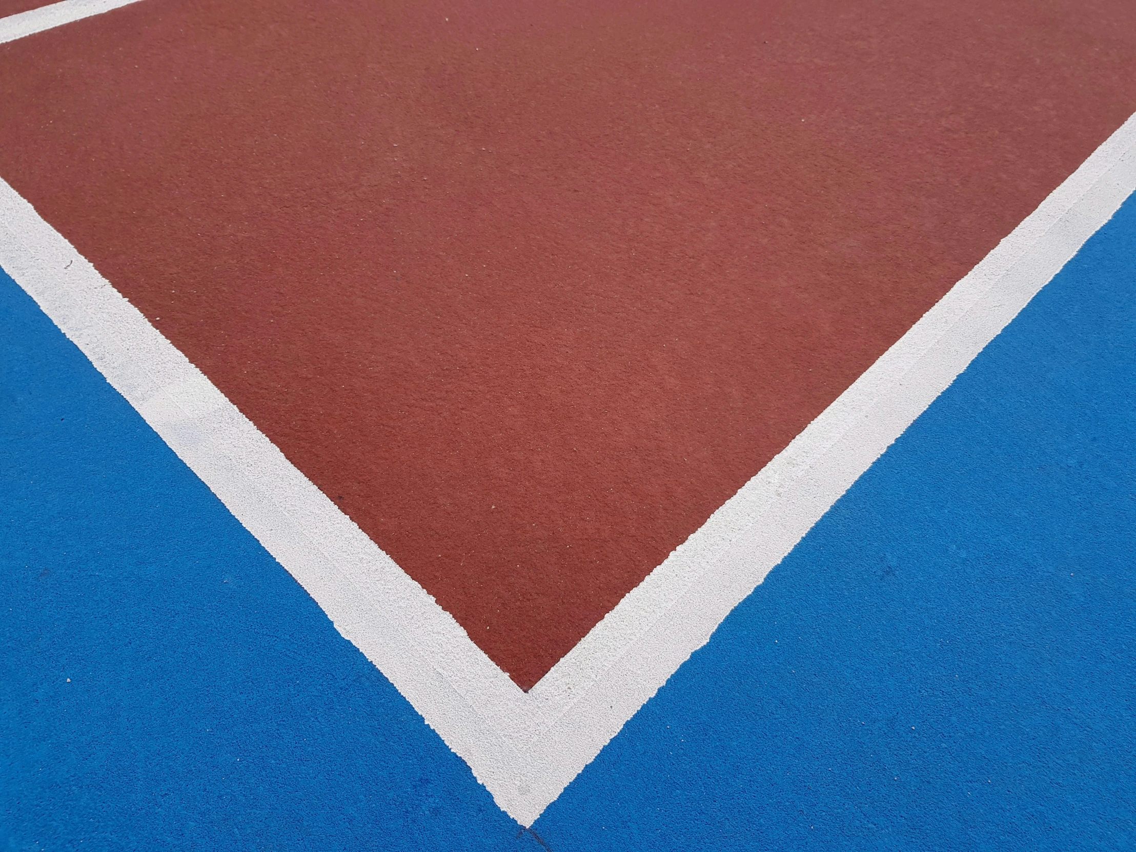 a tennis court with a small bird on the ground