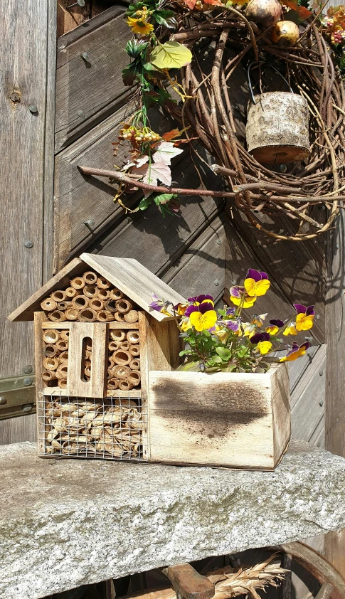 a birdhouse sitting next to a pile of wood