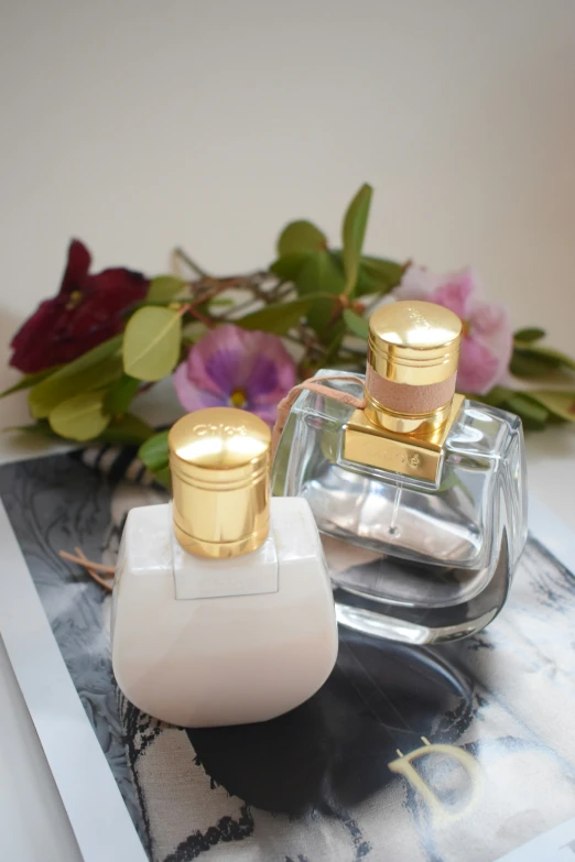 two perfume bottles sitting next to each other on a glass table