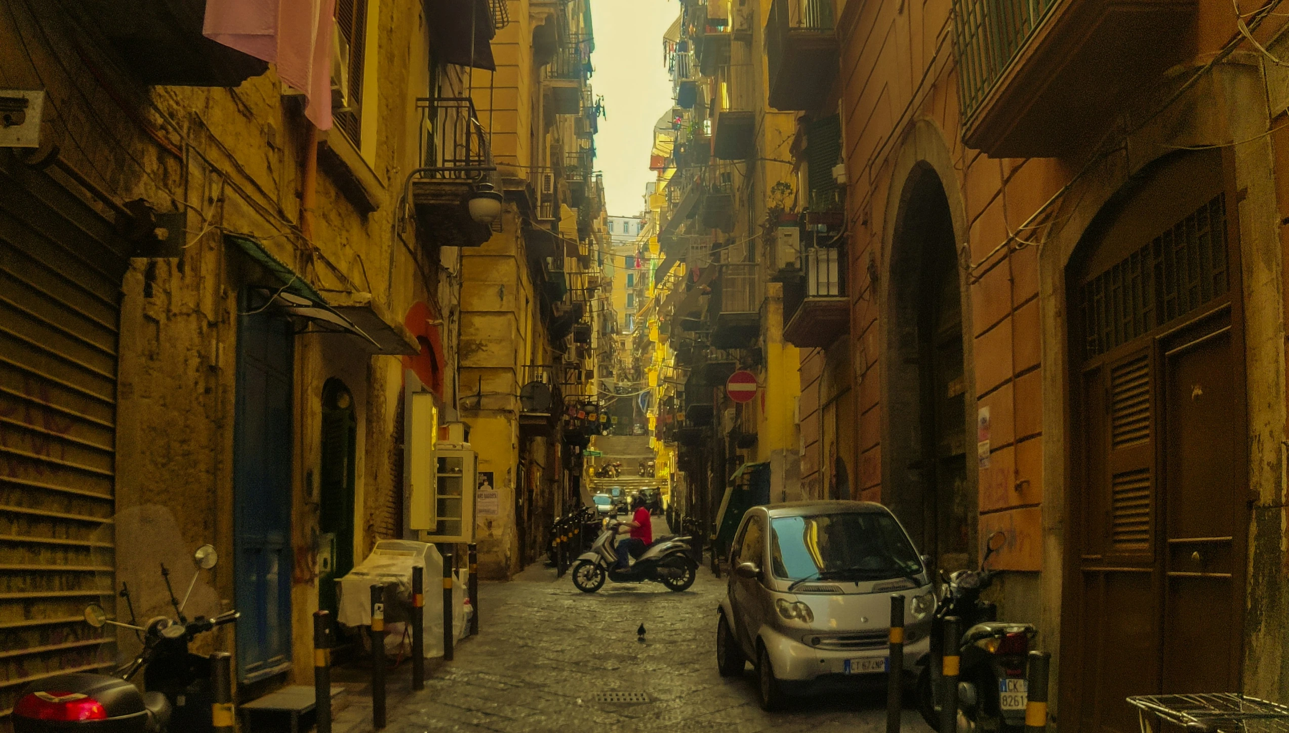 a small car parked at the end of an alley