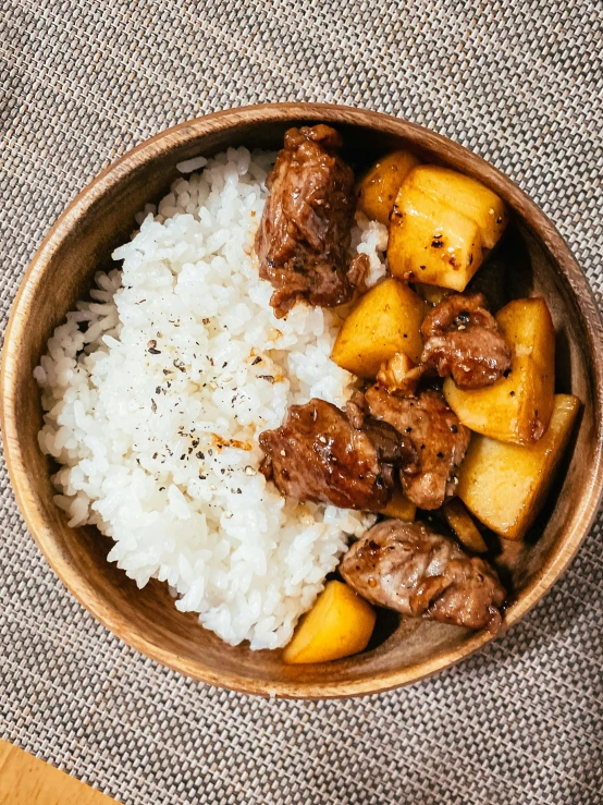 a bowl filled with white rice and beef on top of it