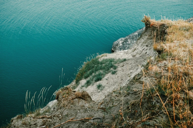 water behind a cliff on a partly calm day