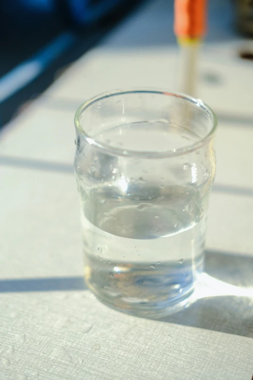 a s glass filled with water and sitting on top of a table