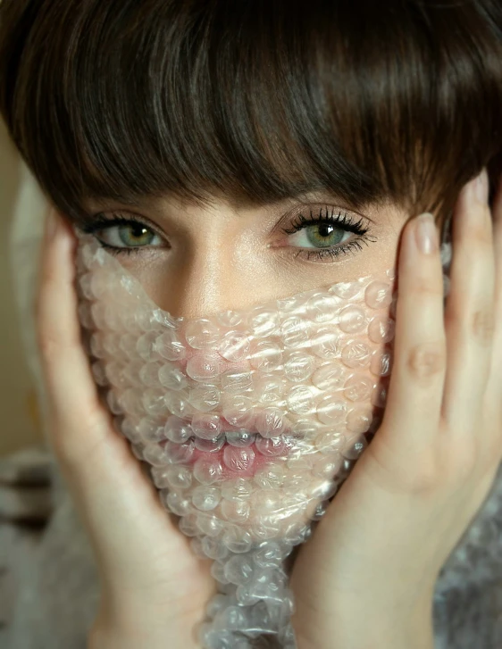 woman covering her face with bubble wrap around her face