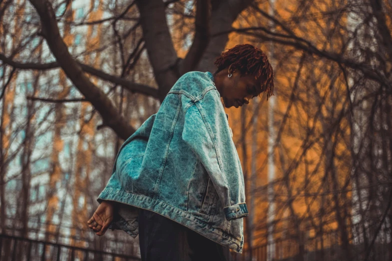 a man with dreadlocks on his head in a park