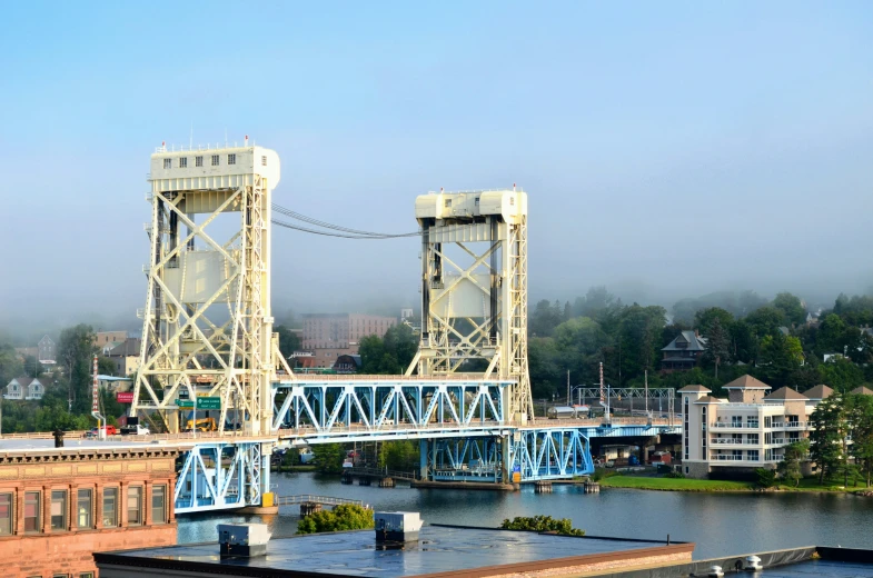 the view of a large metal bridge crossing a river