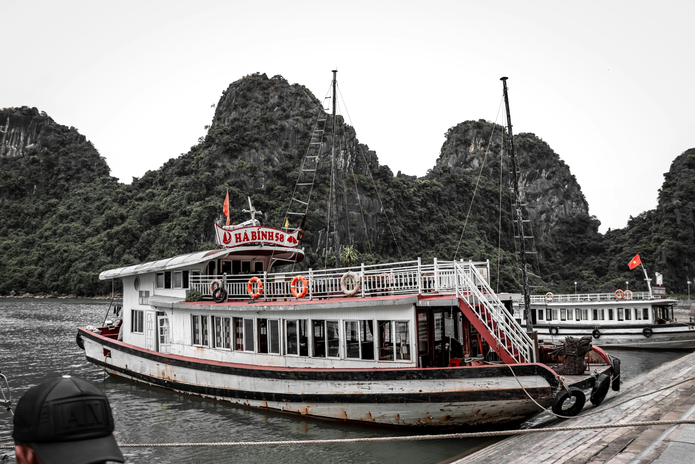 a long boat is in the water at the pier