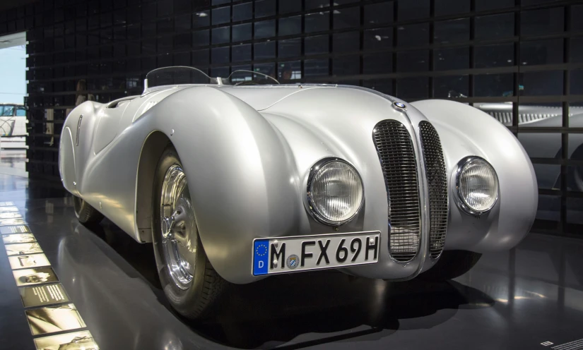 a vintage sports car is parked next to some other vehicles