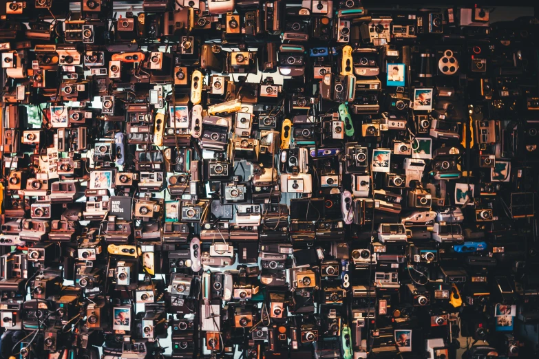 a large array of old time electronic devices, including cameras