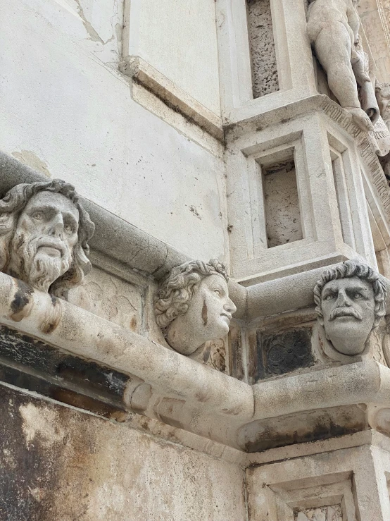 two carved heads on the outside of a building