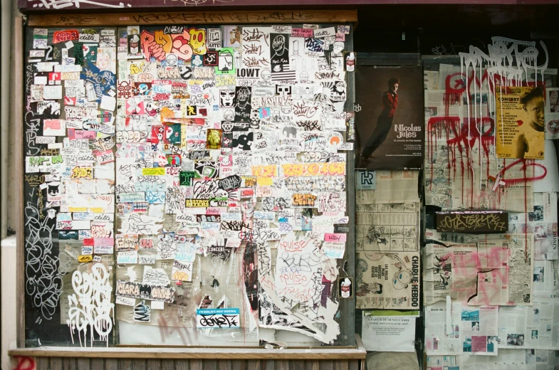 the window of a small building with lots of stickers on it