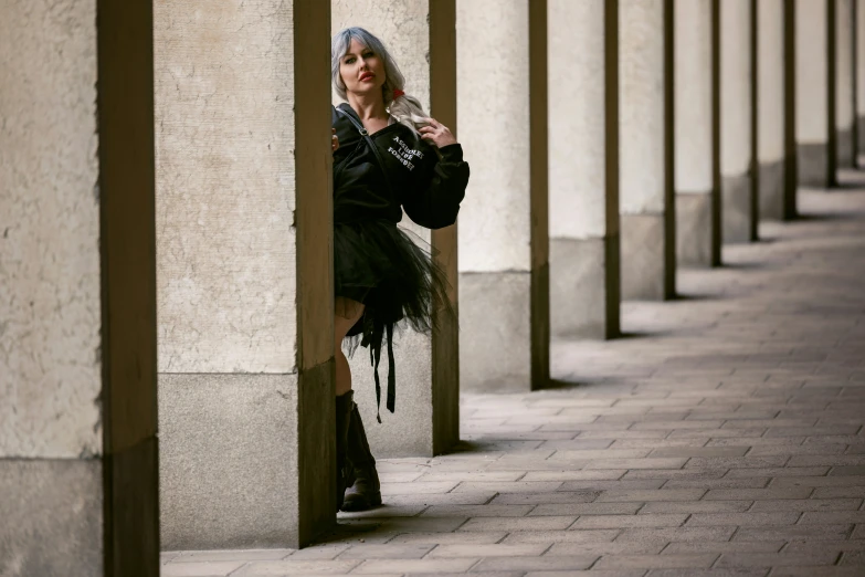 a lady standing behind columns in an outside building