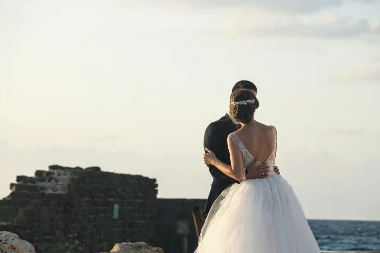 there is a couple standing together on the shore