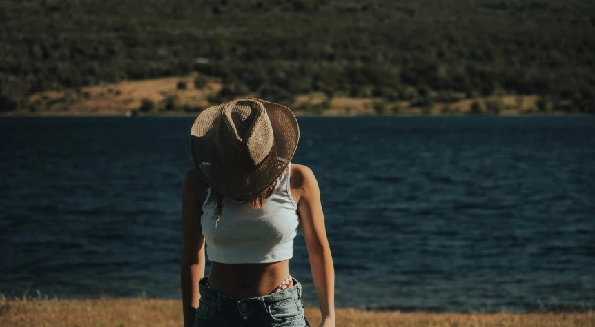 a woman stands near a body of water