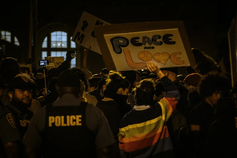 people walking in front of police holding signs