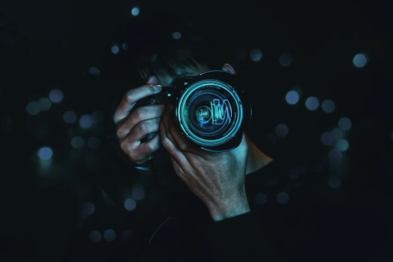 person holding a glowing camera in the dark