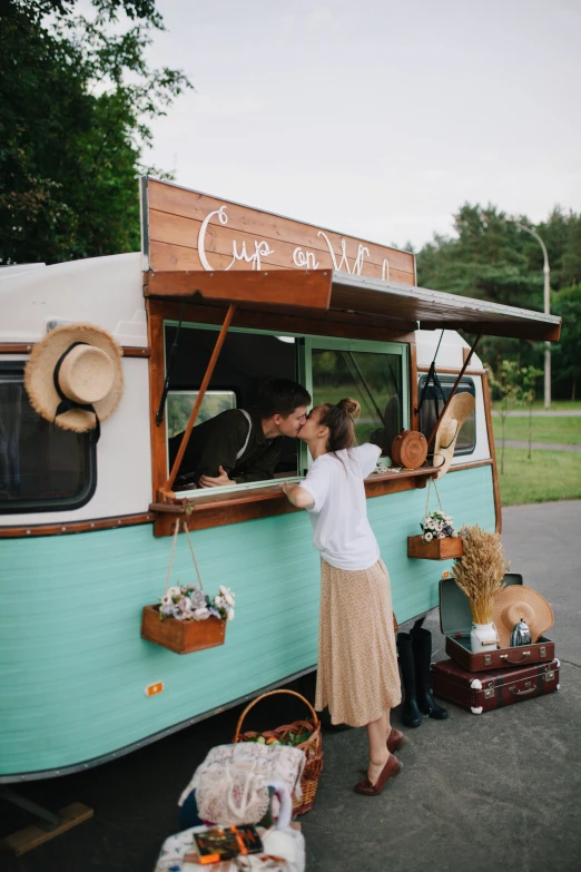 the woman kissing a man at the window of an rv