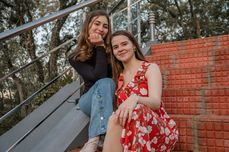 a couple of women sitting on top of a stairway