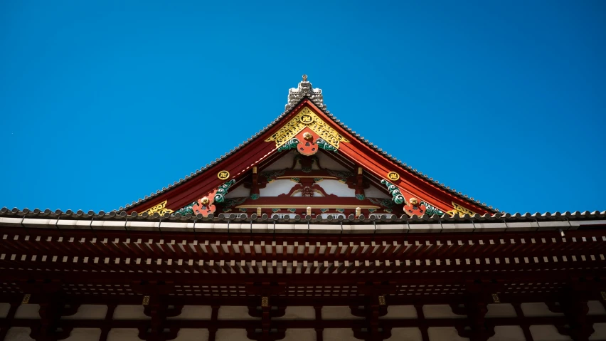 a roof with a decorative architectural feature in the background