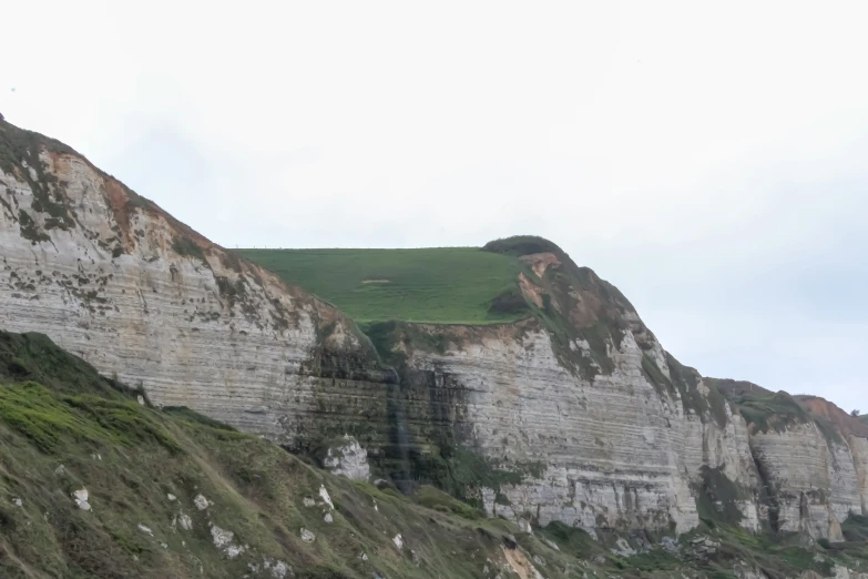 a mountain side with a grass covered hillside