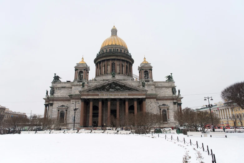 a building with a large golden dome on top and white snow in front