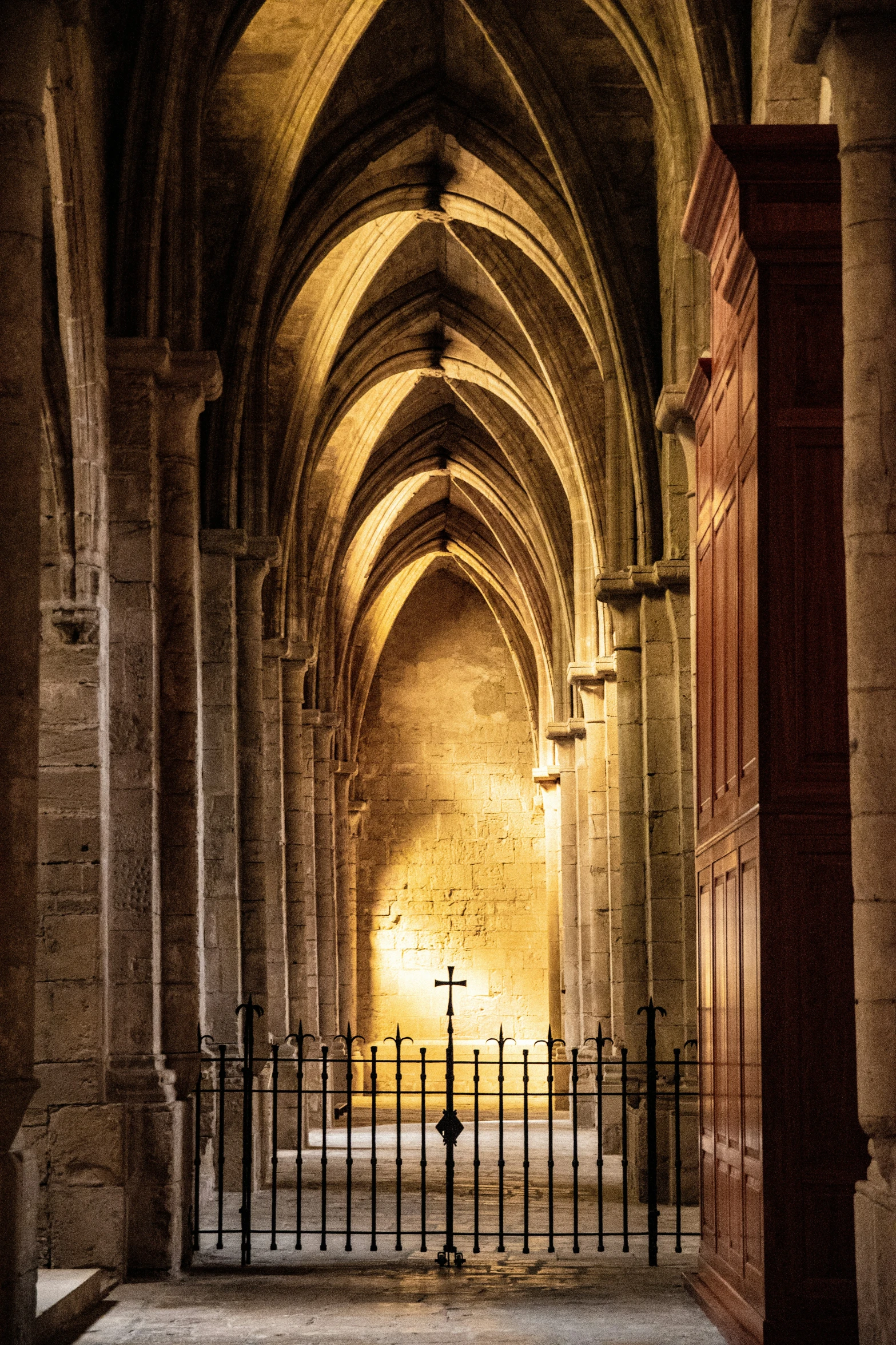 the light at the end of a cathedral shines on the stone floor