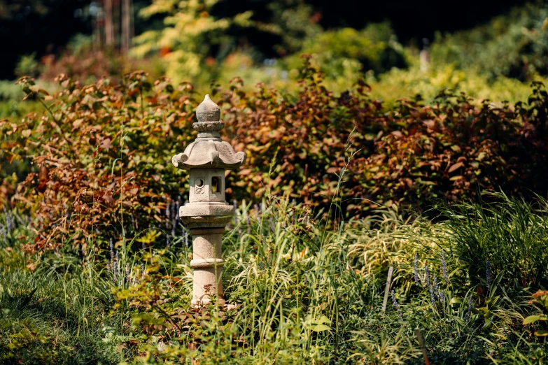 there is a large stone lantern in the middle of some flowers