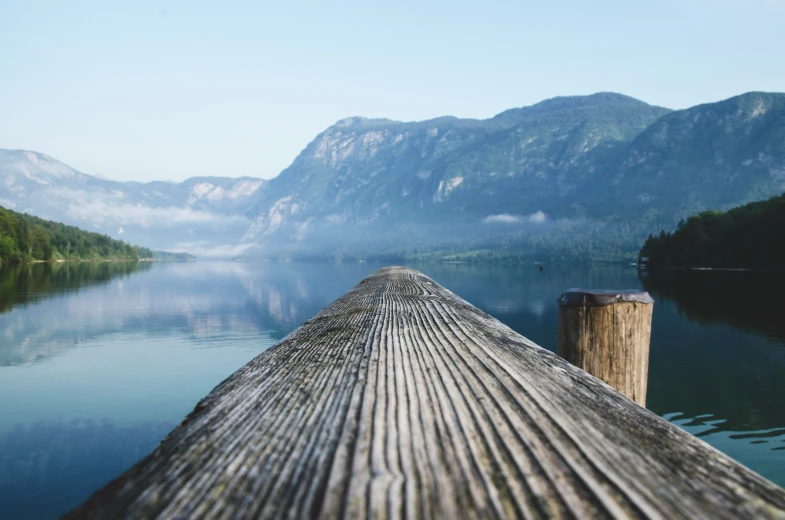 a dock extending into the water surrounded by mountains