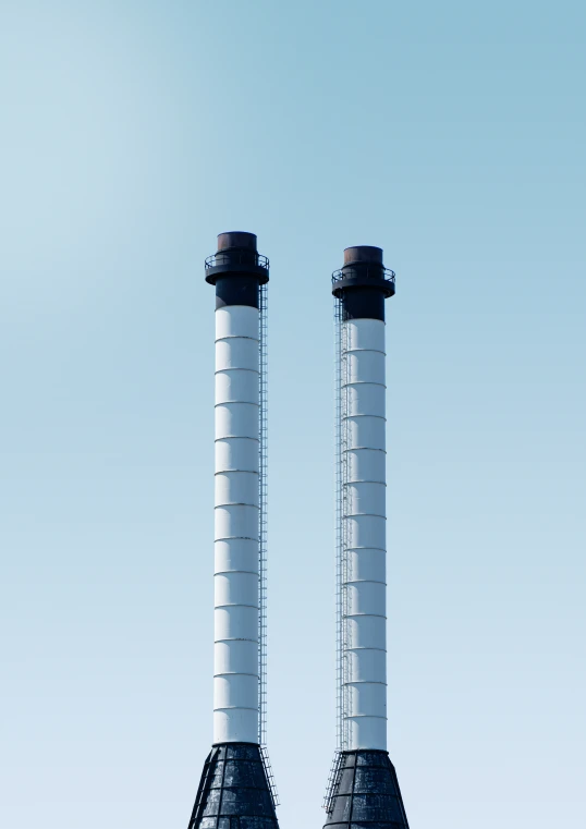 two white pillars with black tops stand over another pole