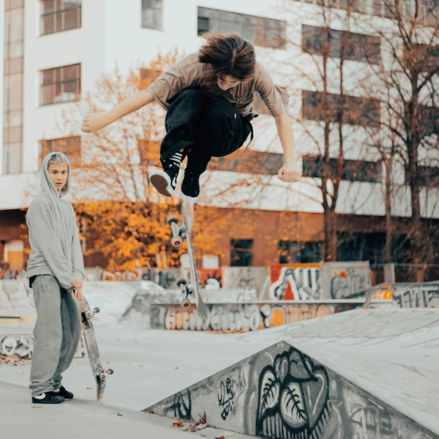skateboarder in mid air as another performs a stunt