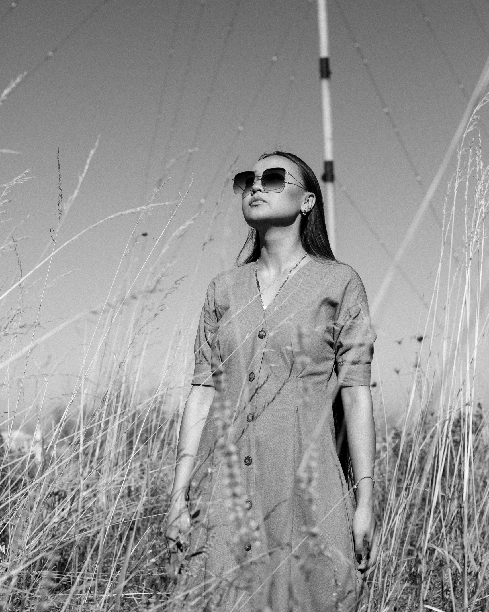 a woman standing in the middle of some tall grass