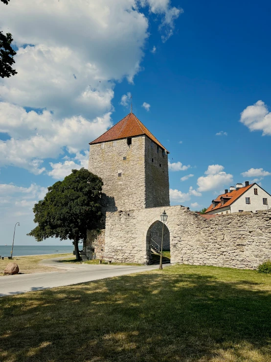 an old, stone church with red roofed roofs on a sunny day