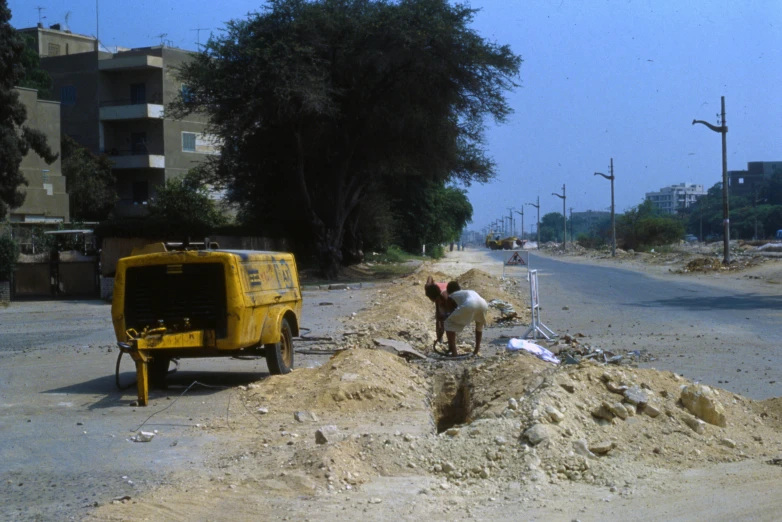 two people near a construction site in front of an electric device