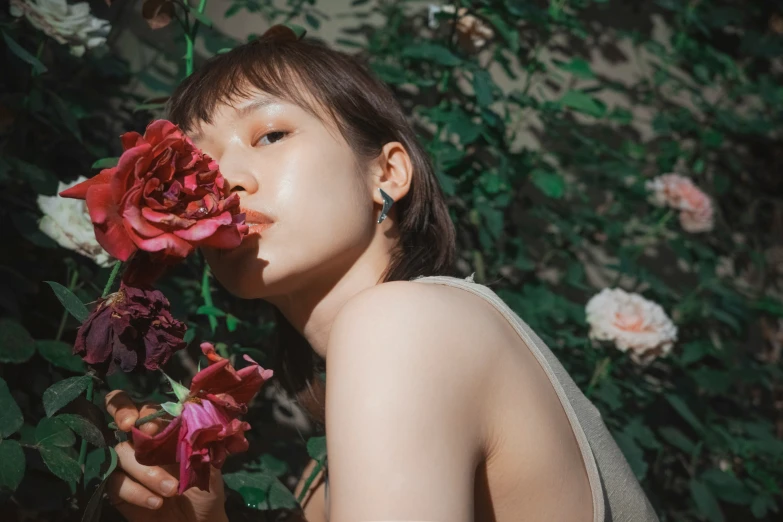 an asian woman holding flowers in her hands