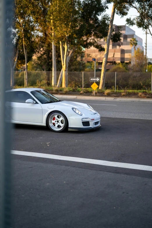 a white sports car parked by the side of the road