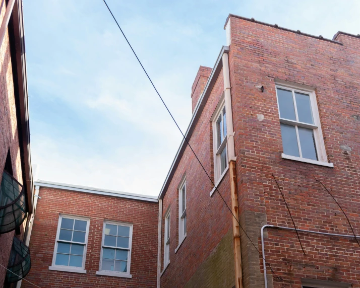 the corner of two brick buildings with windows