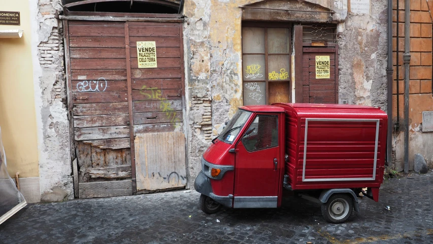 a red truck parked on the street in front of old buildings