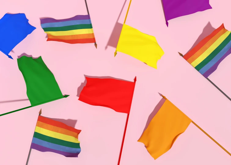 several rainbow colored flags are hanging on a pole