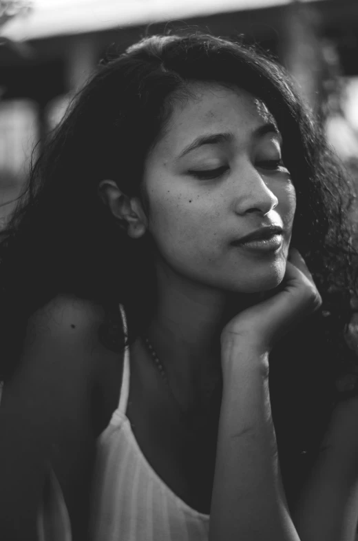 black and white pograph of woman resting on wood