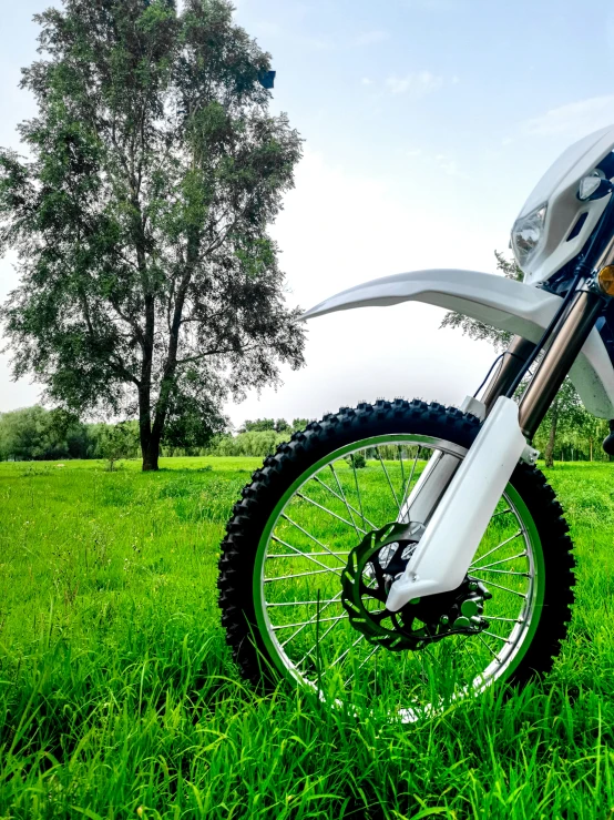 a dirt bike sits parked in the grass