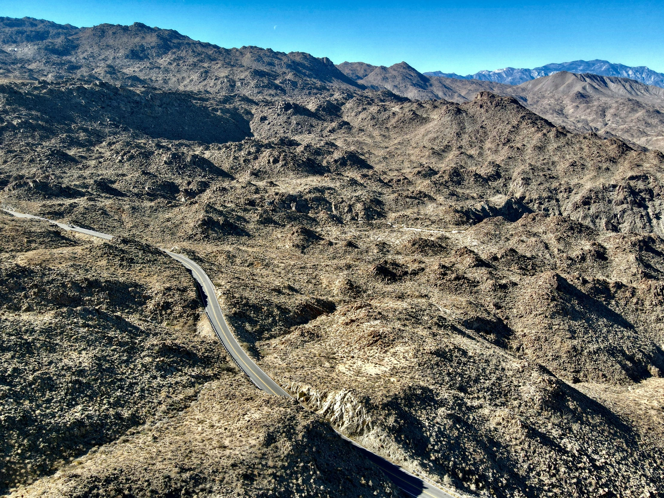 the mountains surrounding a road surrounded by trees