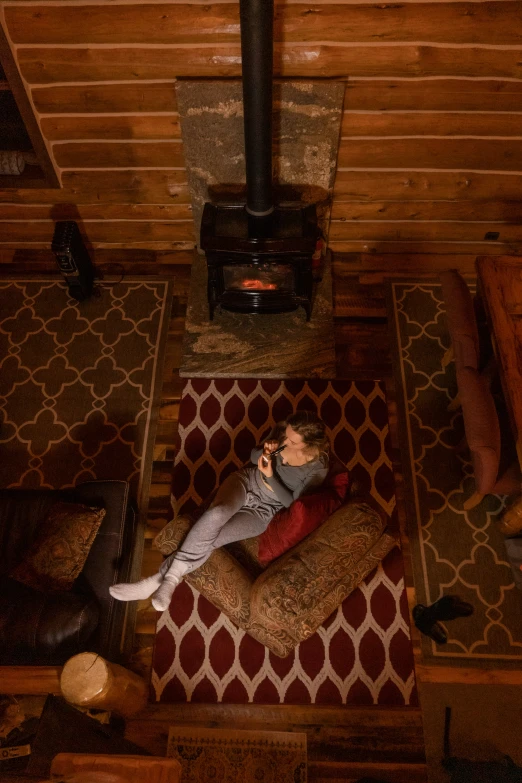 a man taking a picture in a living room by a wood stove